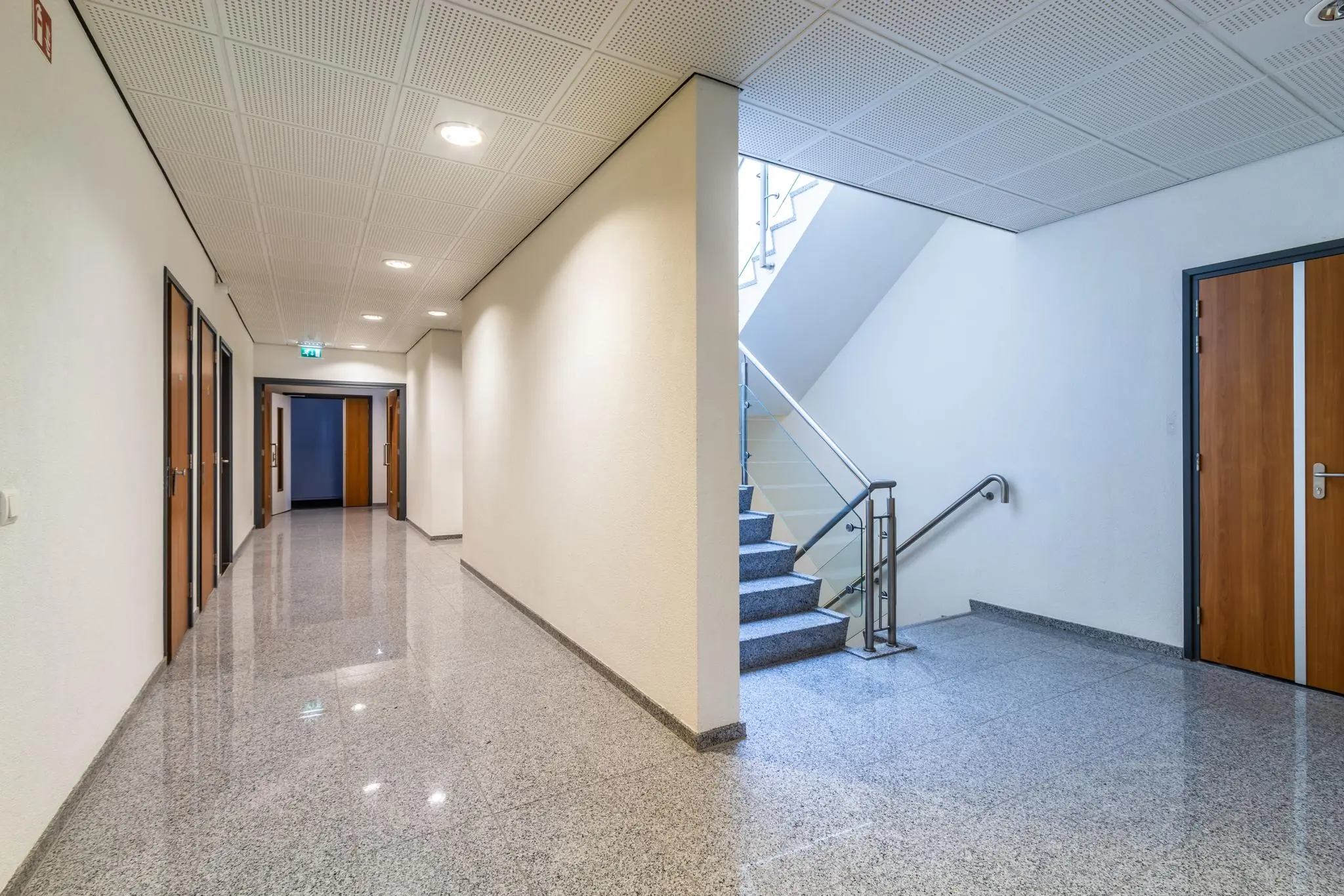 Heldere en moderne gang in een kantoorgebouw aan de Lange Dreef met een trap naar boven en meerdere deuren.